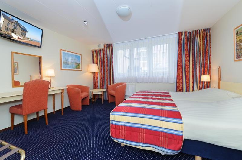 Een bed of bedden in een kamer bij Boulevard Hotel Scheveningen