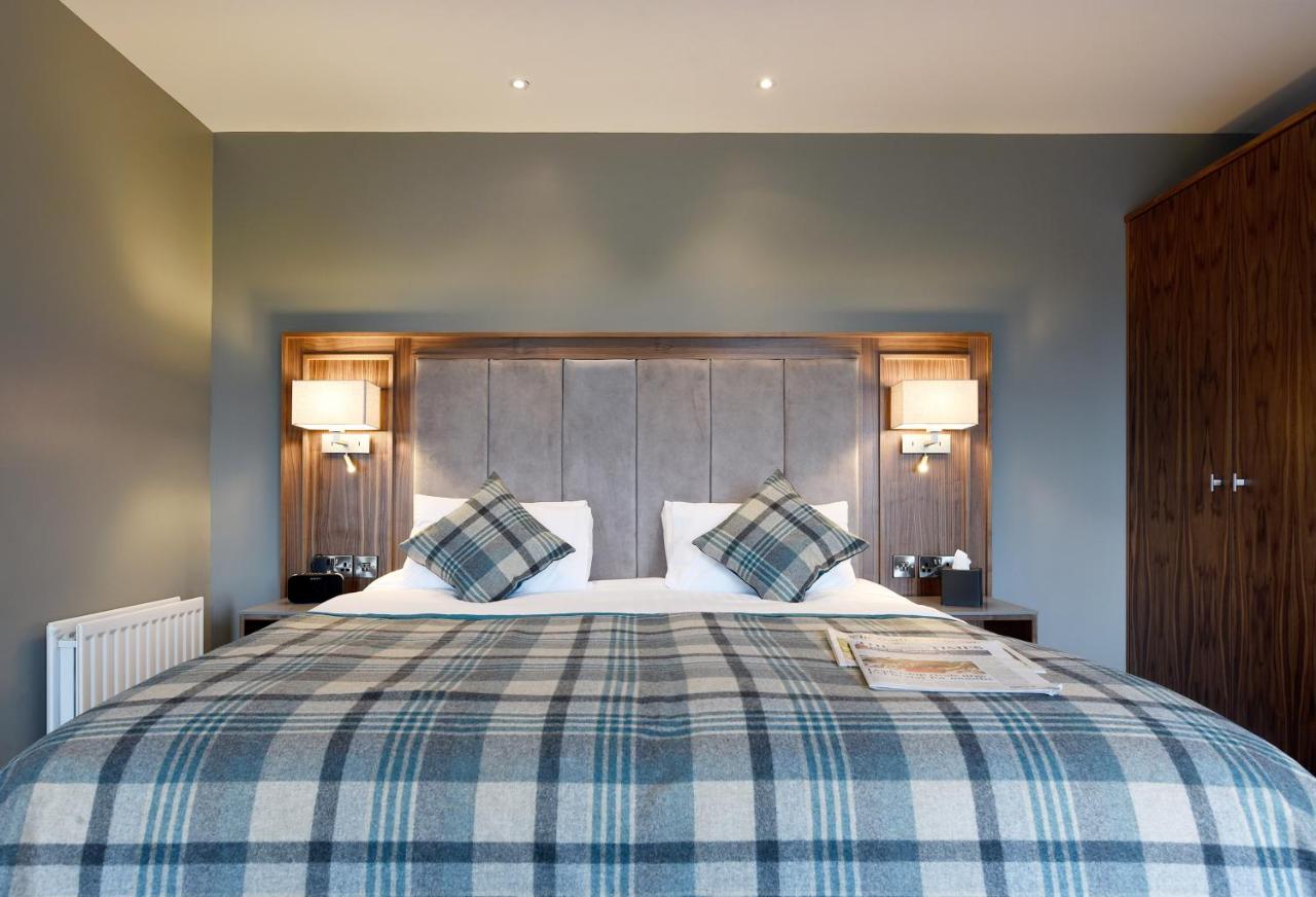 Hotel room with a stylish double bed and plaid bedding.