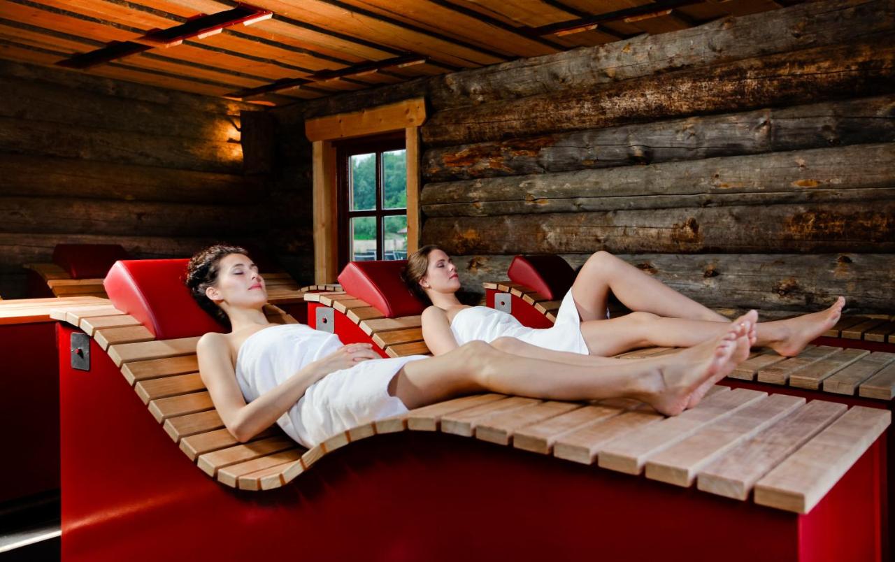 two women sitting on a bed in a room at Hotel Thermen Bussloo - Apeldoorn in Bussloo