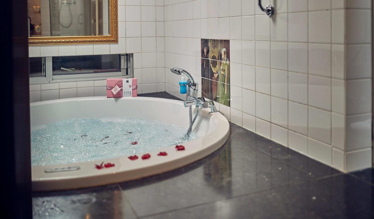 a bath tub with a faucet in a bathroom at Landgoed Groot Warnsborn in Arnhem