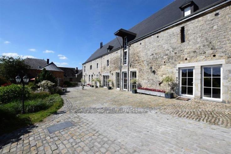 a large brick building with a driveway in front of it at La Belle Étable in Dinant