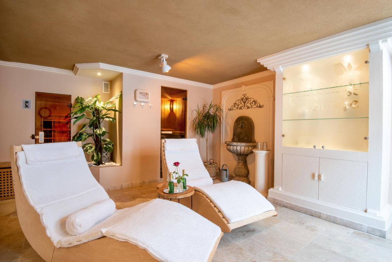 a room with two white chairs and a mirror at Hotel Eifelland in Butgenbach