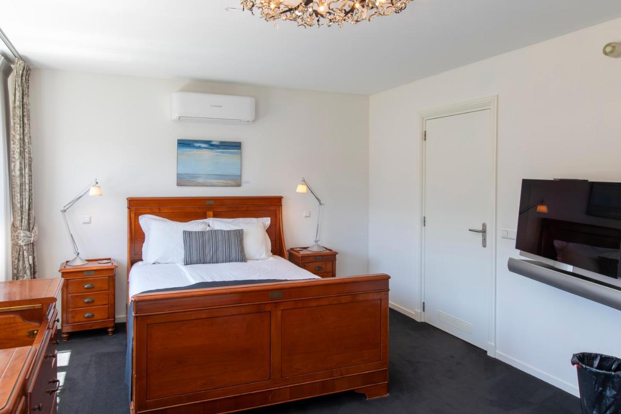 a bedroom with a bed and a flat screen tv at Hotel La Rosa Amsterdam Beach in Zandvoort