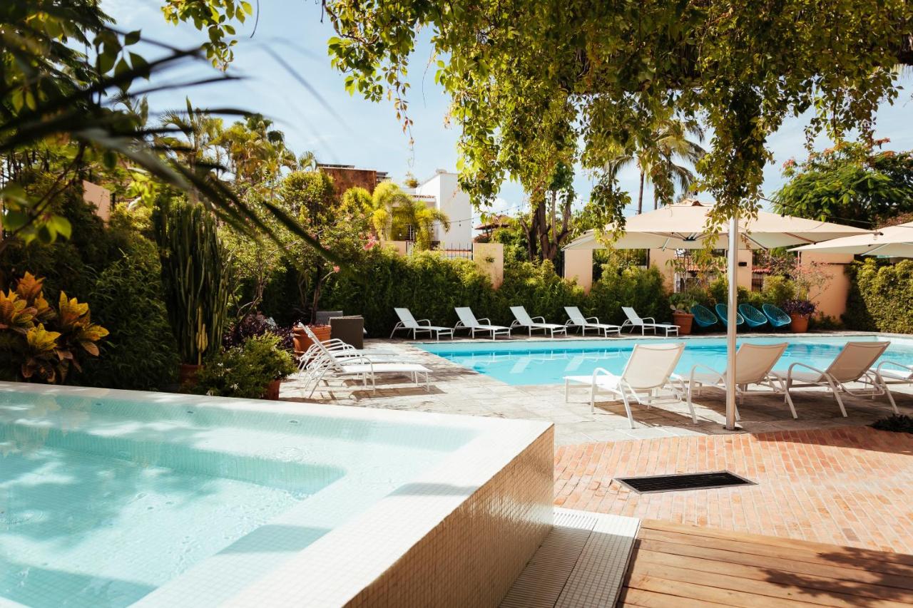 hotel swimming pool with white sun chairs around it