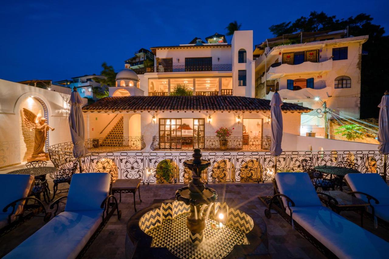 white hotel at night with loungers on balcony