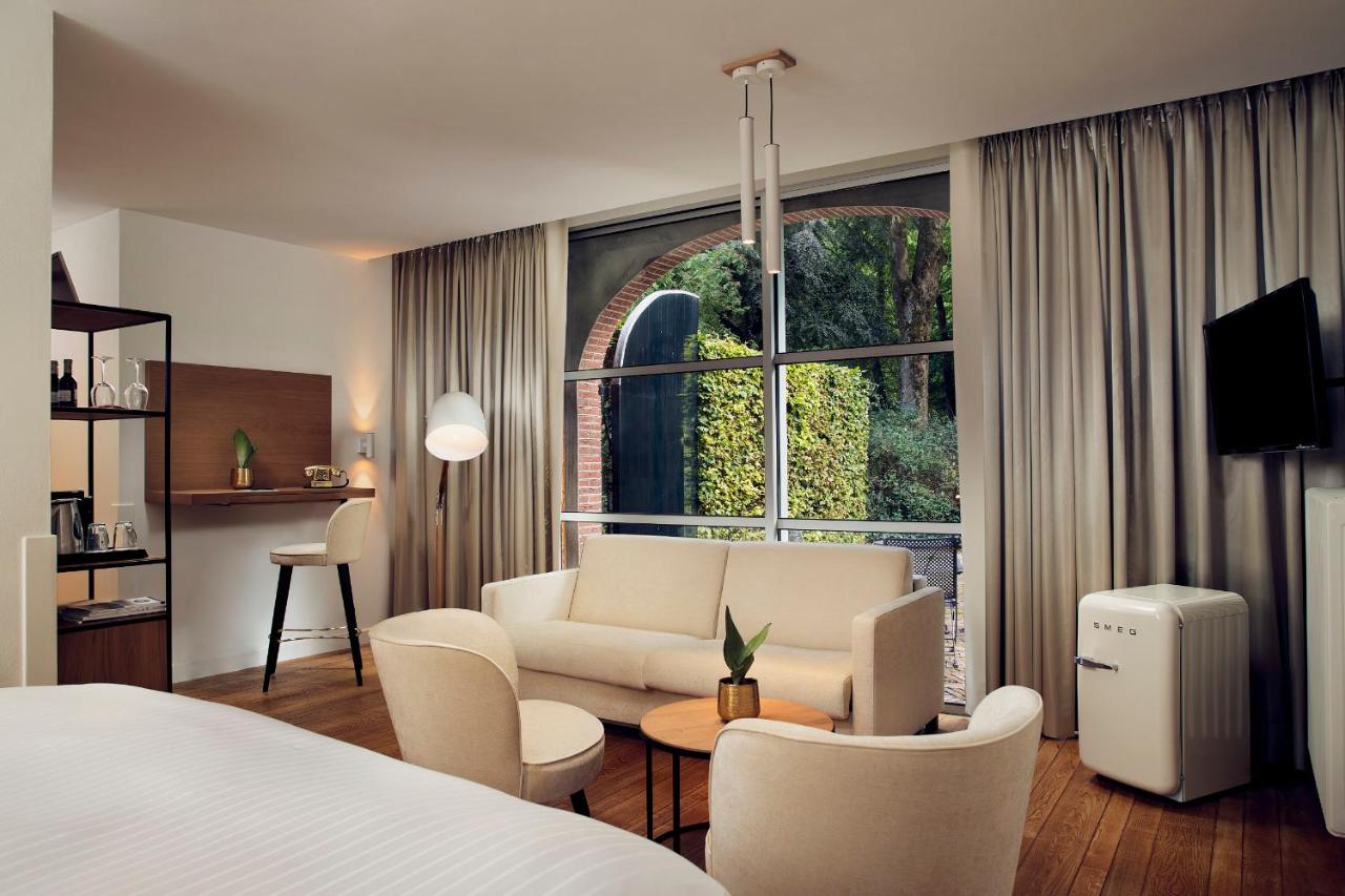 a hotel room with a bed and a living room at Landgoed Groot Warnsborn in Arnhem