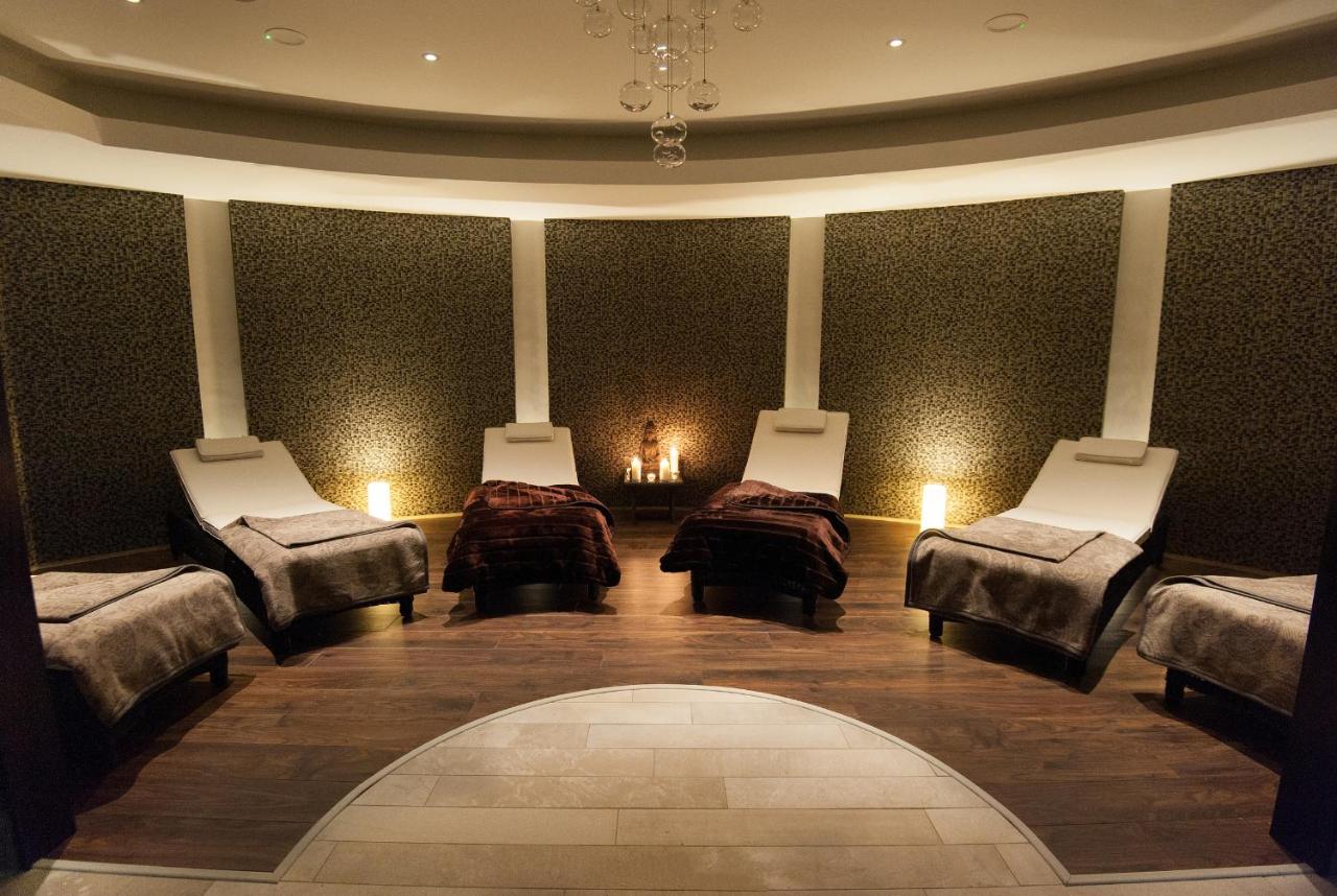 Indoor pool with two people relaxing and ambient lighting.