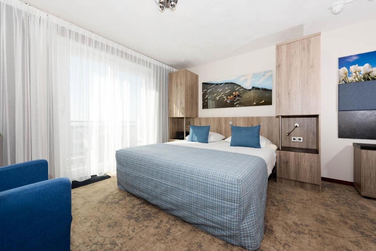 Een bed of bedden in een kamer bij Strandhotel de Vassy