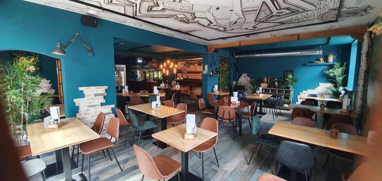 a restaurant with blue walls and tables and chairs at Hotel Heere in Raamsdonksveer