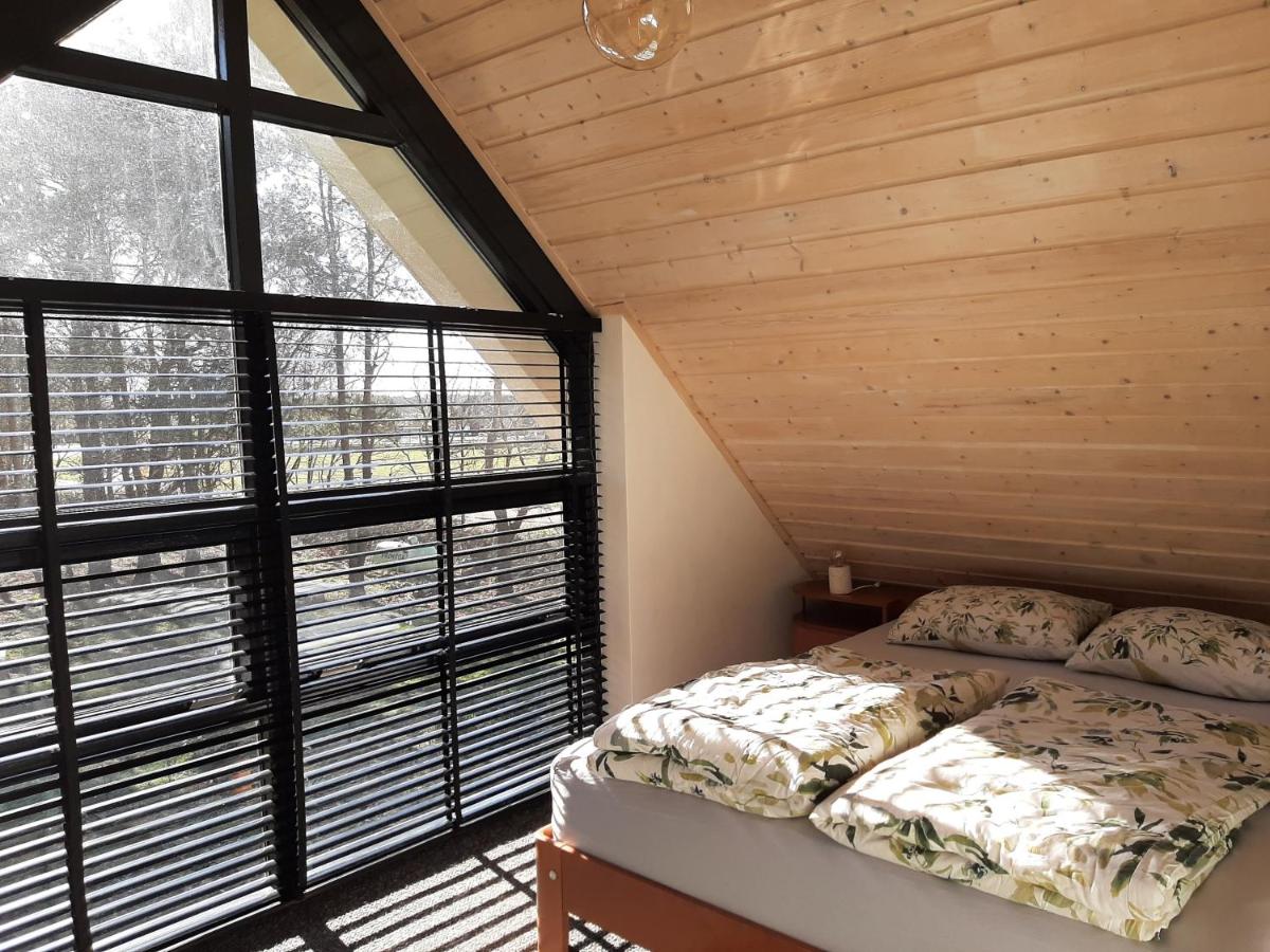 a bedroom with a bed and a large window at Vakantiehuis met hottub en barrelsauna in Ommen