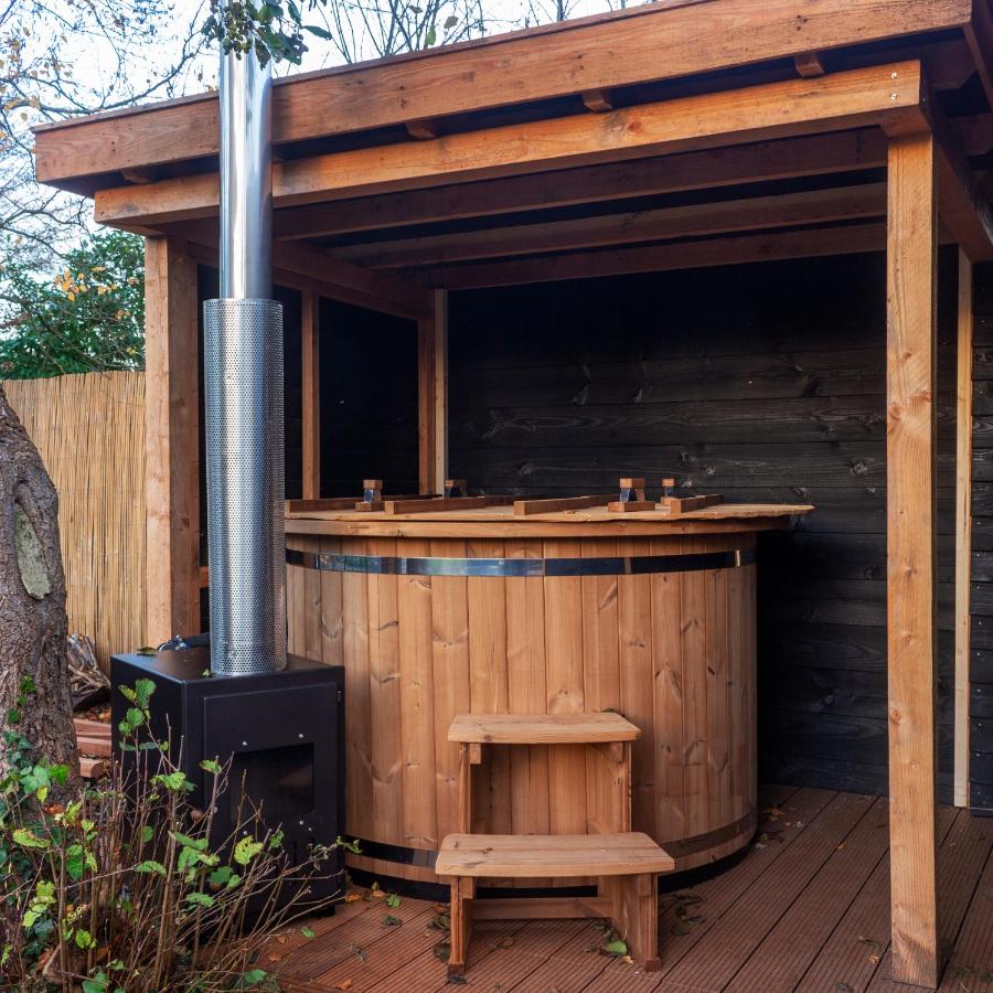 a wooden bar with a stool next to a stove at Casa aan de Plas, B&B met sauna en hottub of jacuzzi in Nieuwkoop