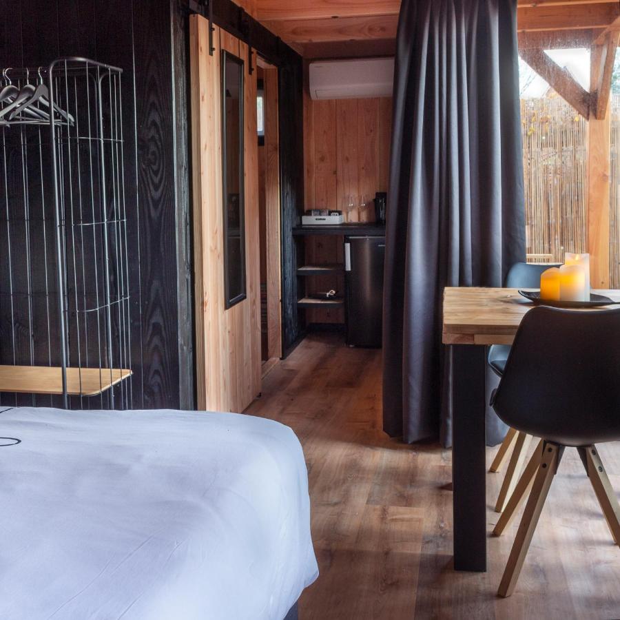a bedroom with a bed and a table with a chair at Casa aan de Plas, B&B met sauna en hottub of jacuzzi in Nieuwkoop