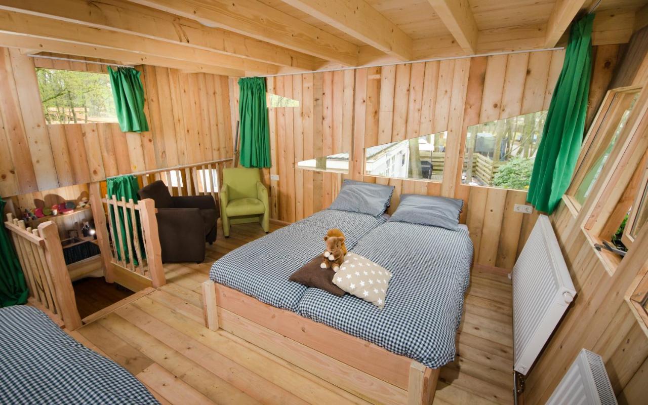 Een bed of bedden in een kamer bij Recreatiepark d'n Mastendol luxe Boomhutten