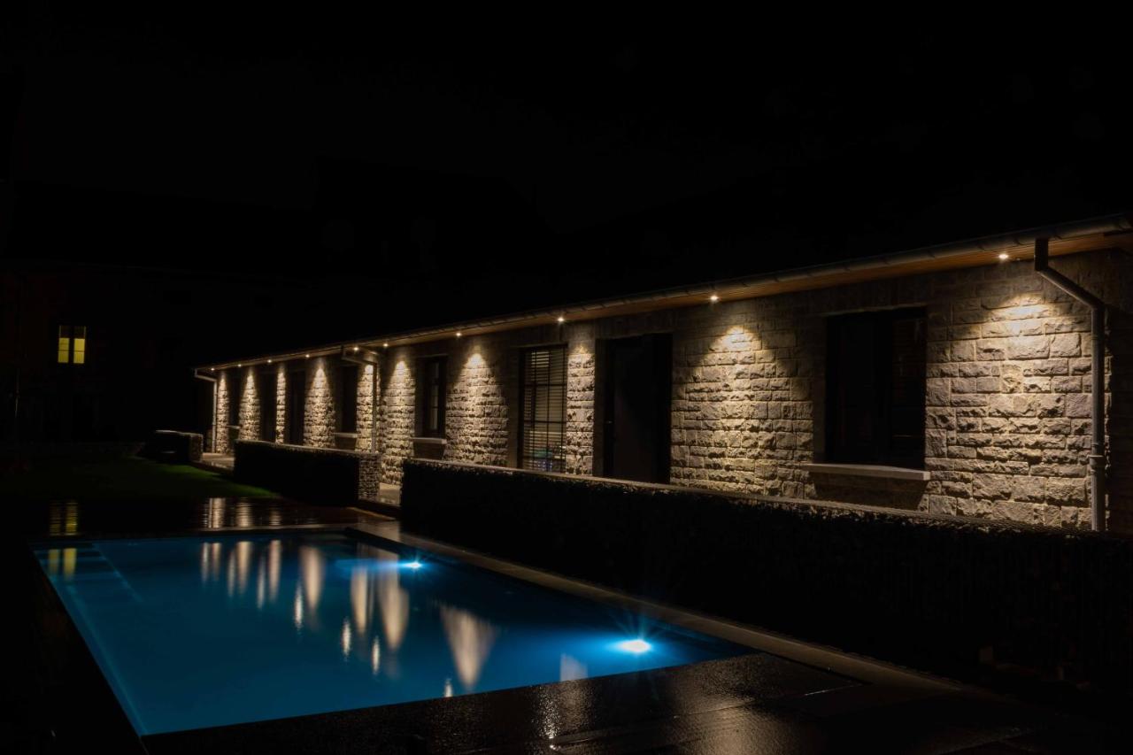 a building with a swimming pool at night at B&B Au Cœur de Han in Han-sur-Lesse