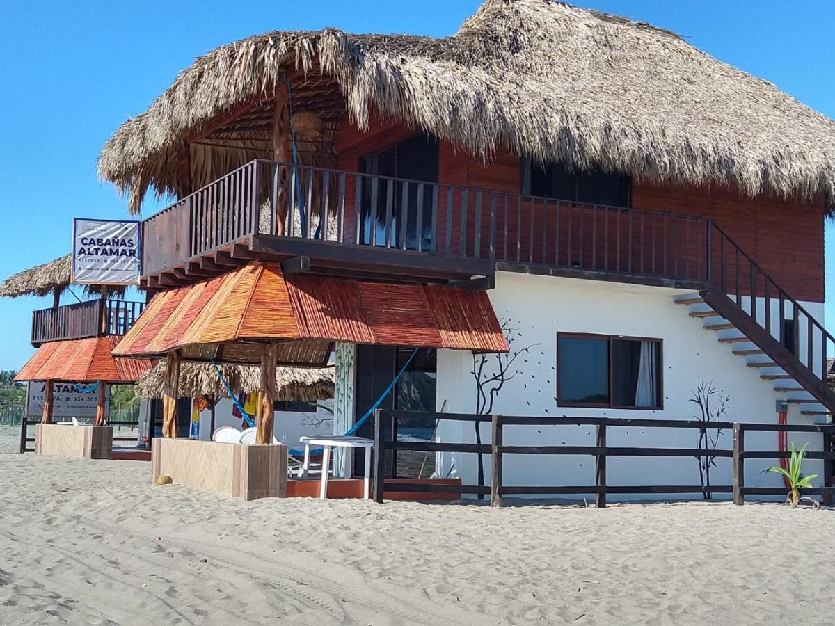 exterior of Cabañas Alta Mar, two story hotel with dried palm leaves roof, hotel in Chacahua near the beach