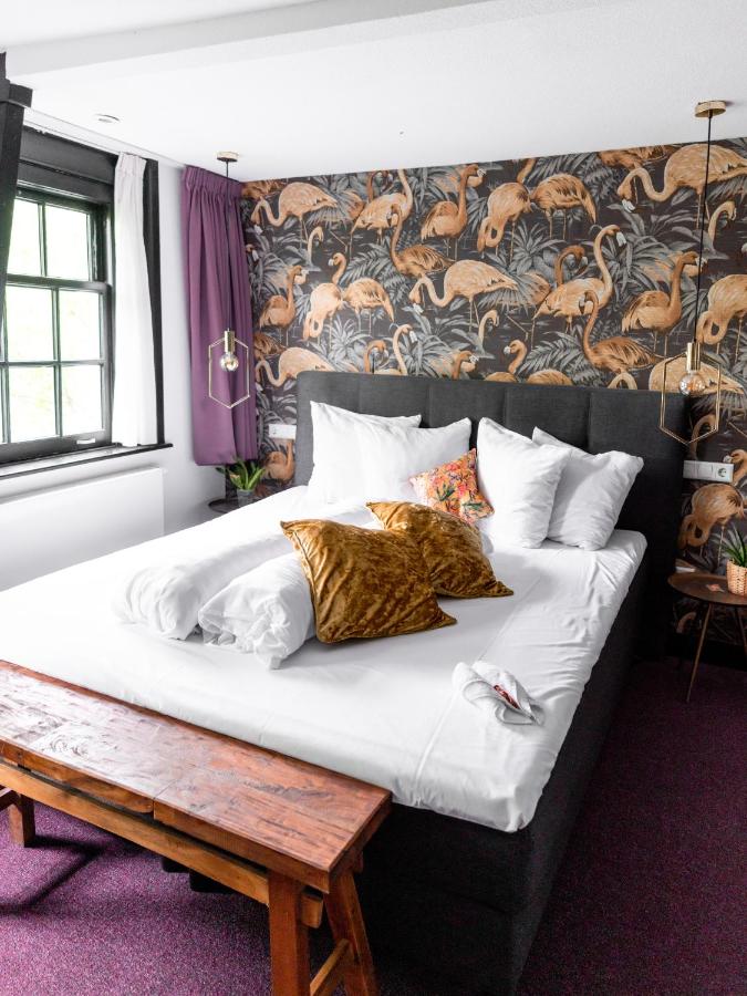 a large bed with pillows on it in a bedroom at Wolf Hotel Kitchen & Bar in Alkmaar