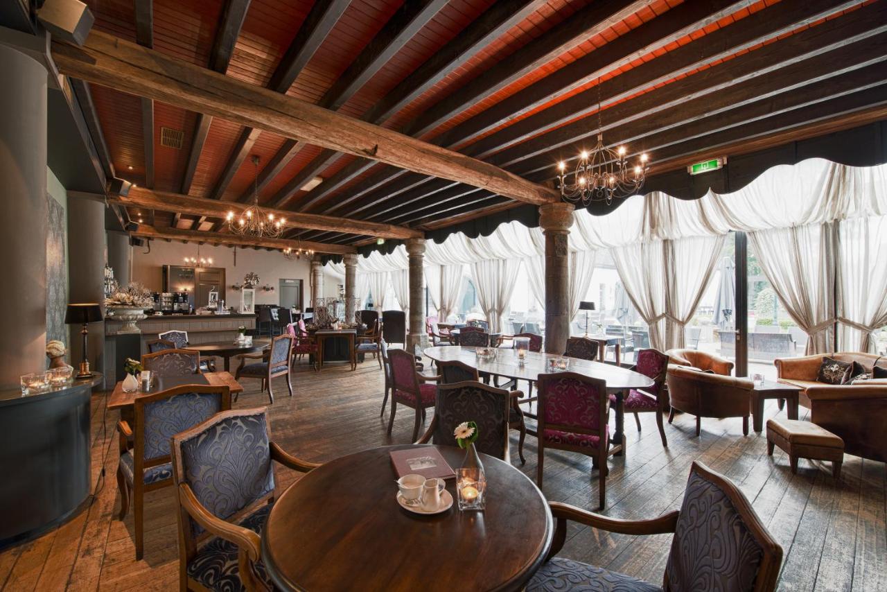 a restaurant with wooden ceilings and tables and chairs at Romantik Hotel Kasteel Daelenbroeck in Herkenbosch