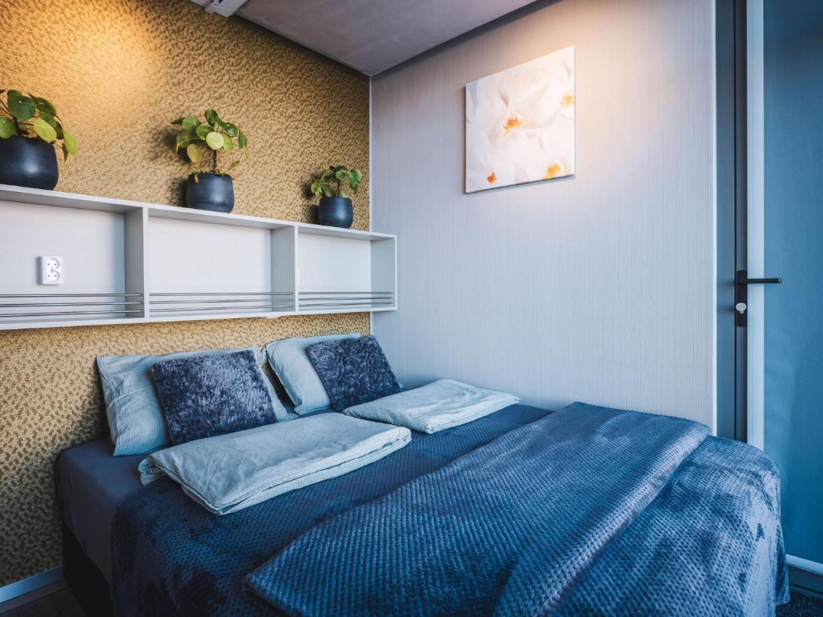a bedroom with a blue bed with pillows on it at AquaHome - NP de Biesbosch - Bijzonder overnachten op een houseboat! in Werkendam