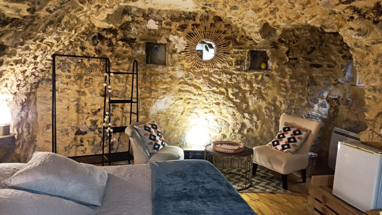 a bedroom with a bed and a stone wall at Chambre de charme 30m2 in Dions