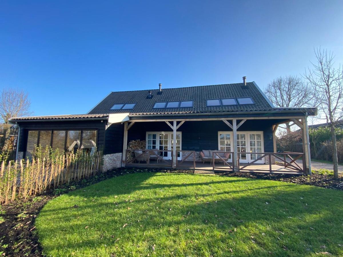 a house with a large yard in front of it at De Porrel Polsbroek Unit met Privé Jacuzzi, Spa en Sauna in Polsbroek
