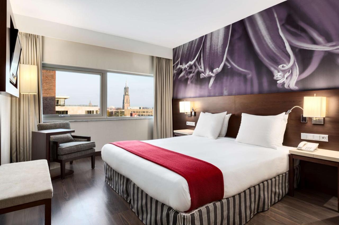a hotel room with a bed and a window at NH Amersfoort in Amersfoort