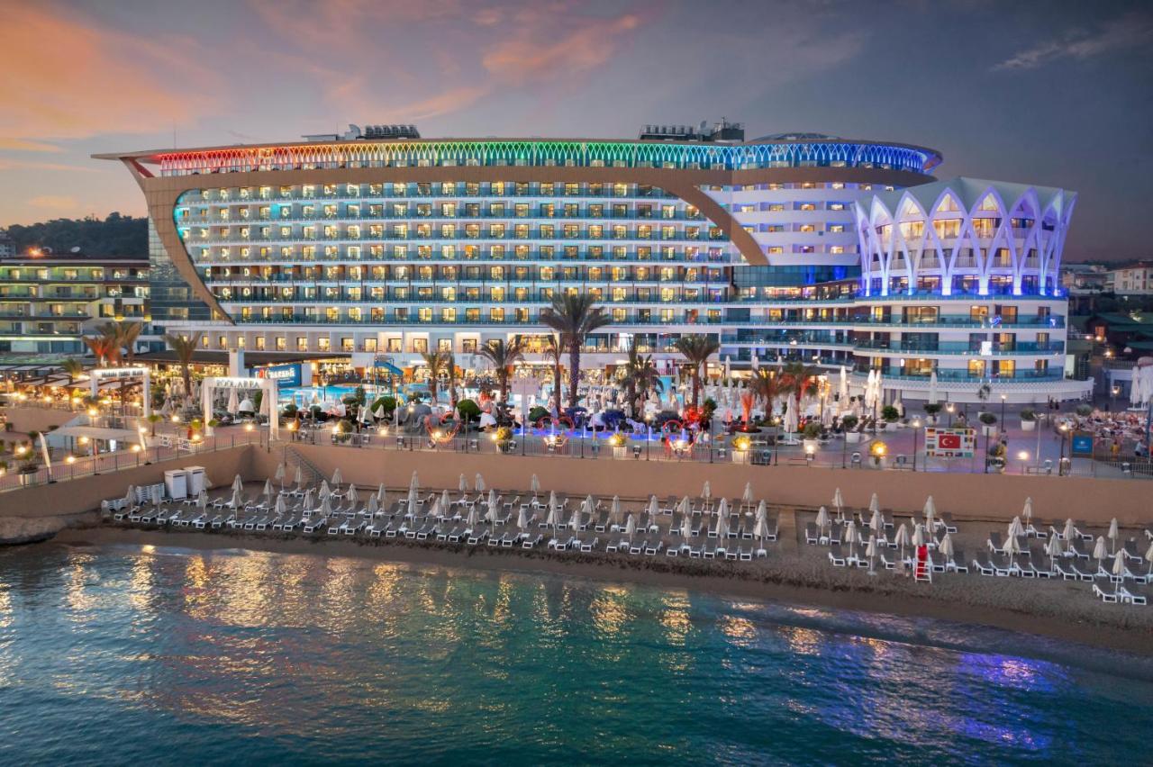 a cruise ship with chairs in front of a building at Granada Luxury Okurcalar in Okurcalar
