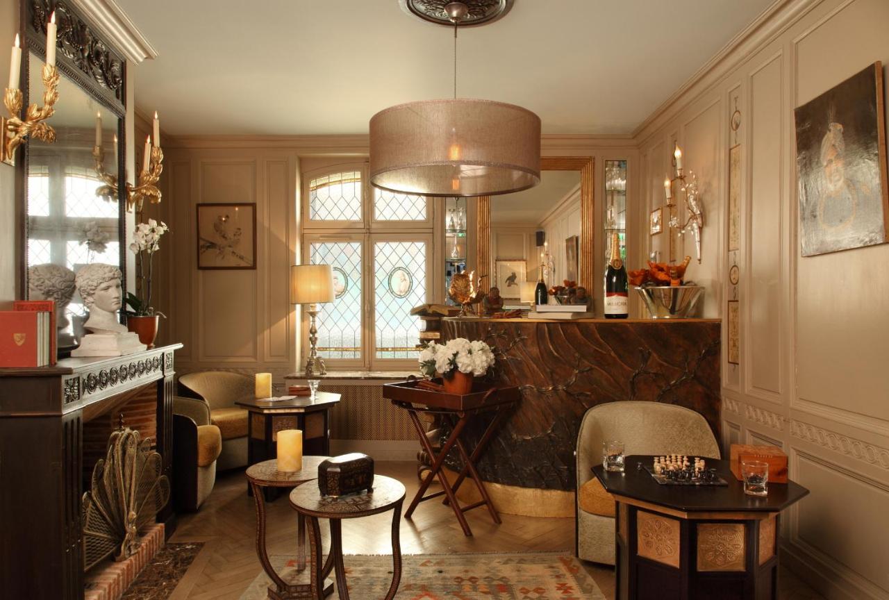a living room with a chandelier and a fireplace at La Maison De Lucie in Honfleur