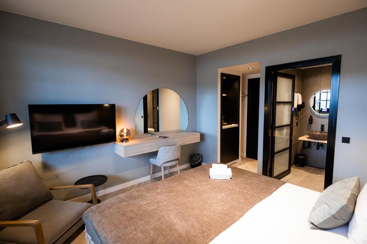 a hotel room with a bed and a mirror at Veluwe Hotel De Beyaerd in Hulshorst