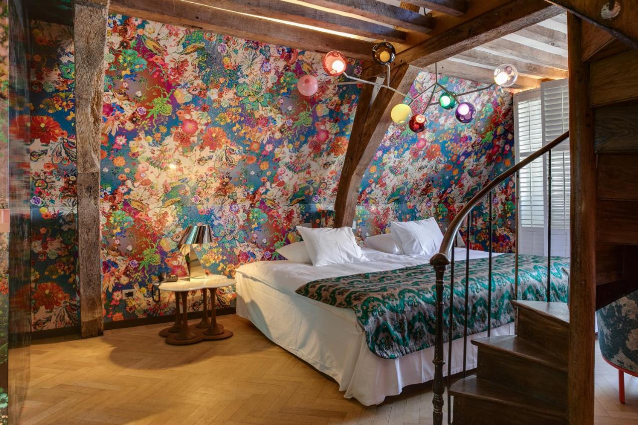 Een bed of bedden in een kamer bij Small Luxury Hotel De Witte Lelie