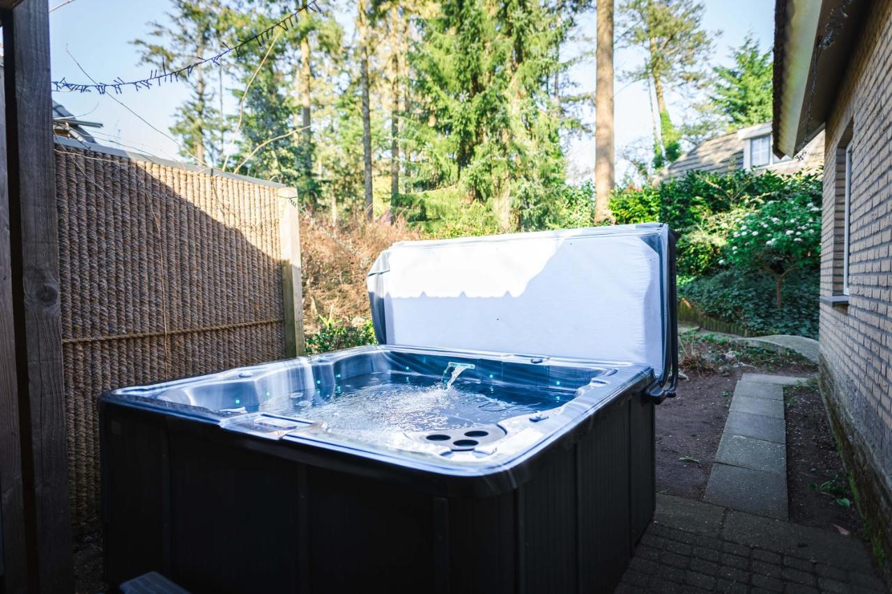 a hot tub in a backyard with water in it at Luxe vakantiehuis in het bos met jacuzzi en sauna in Lunteren