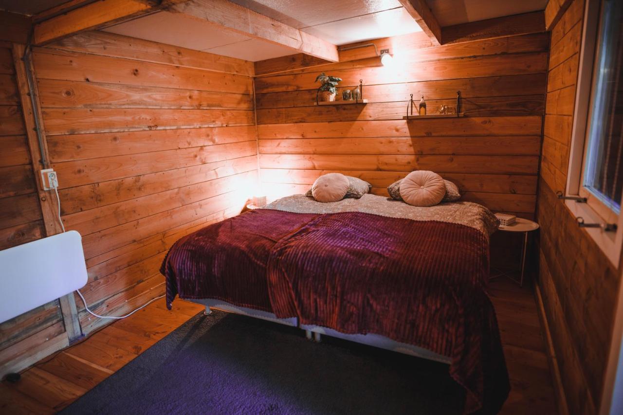 a bedroom with wooden walls and a bed with two pillows at Luxe vakantiehuis in het bos met jacuzzi en sauna in Lunteren