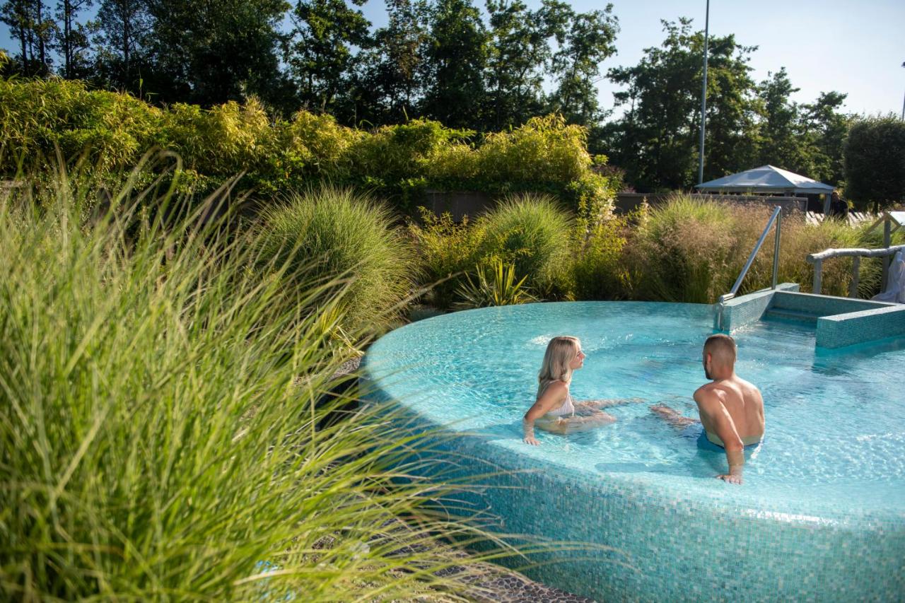 a man and a woman sitting in a swimming pool at Hotel & Wellness Zuiver in Amsterdam