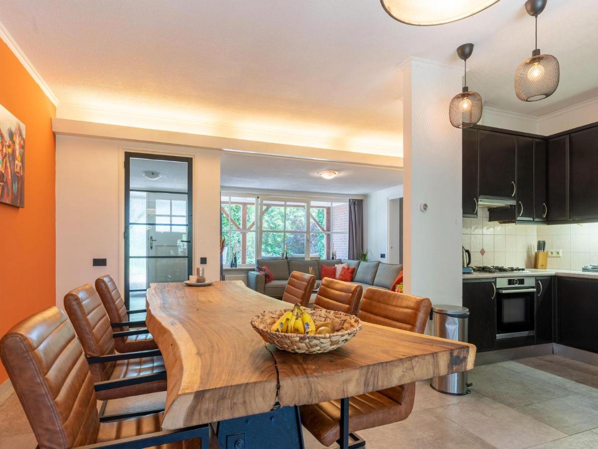 a kitchen and dining room with a wooden table and chairs at House with a large garden in Achterhoek in Eibergen