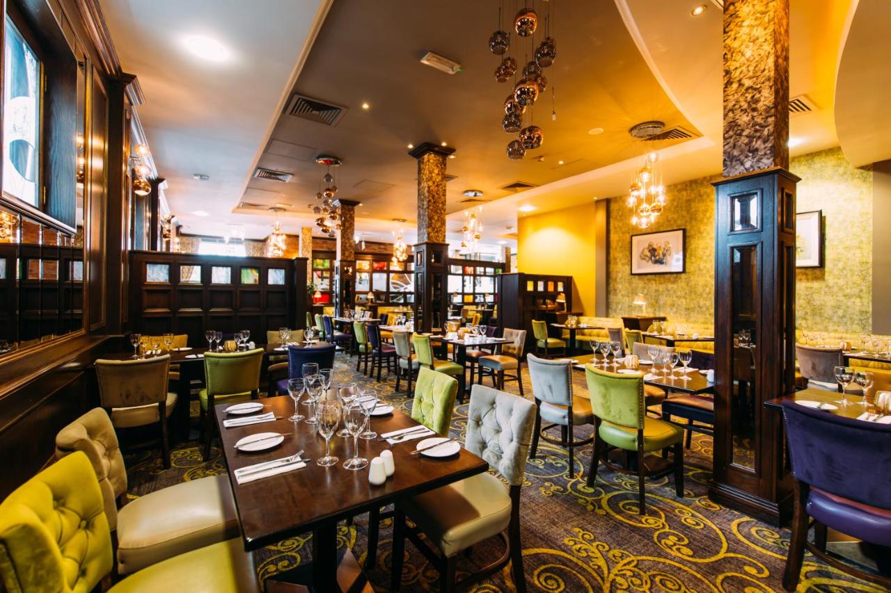 Elegant restaurant interior with colorful chairs and neatly set tables.