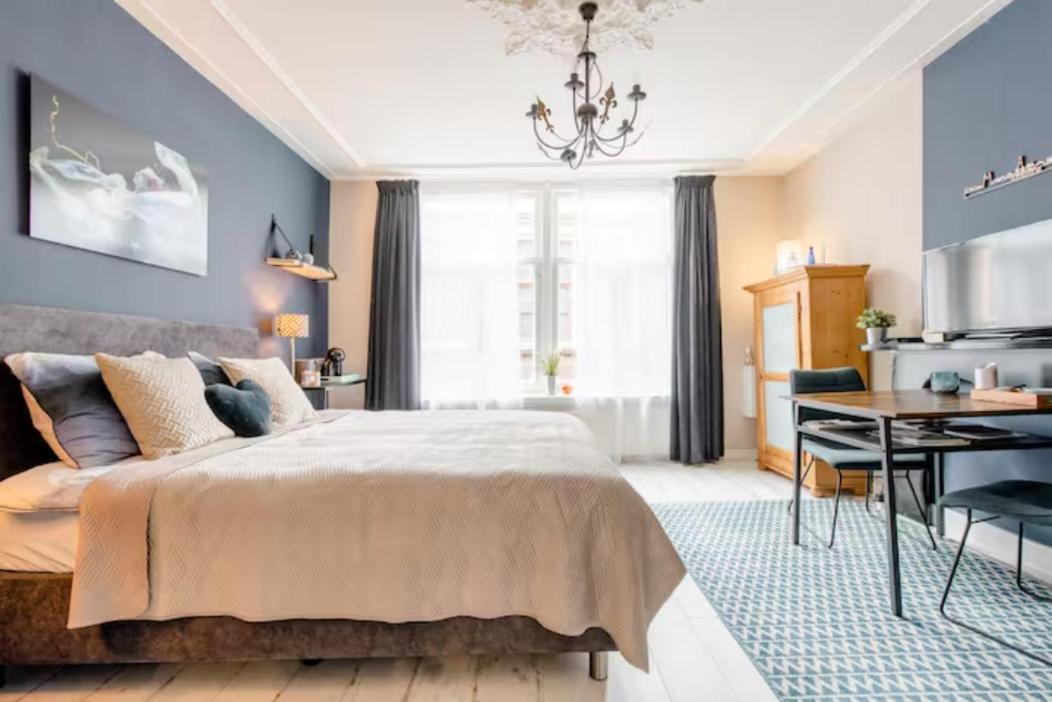 a bedroom with a bed and a table and a dining room at verzorgde kamer in monumentenpand in Arnhem