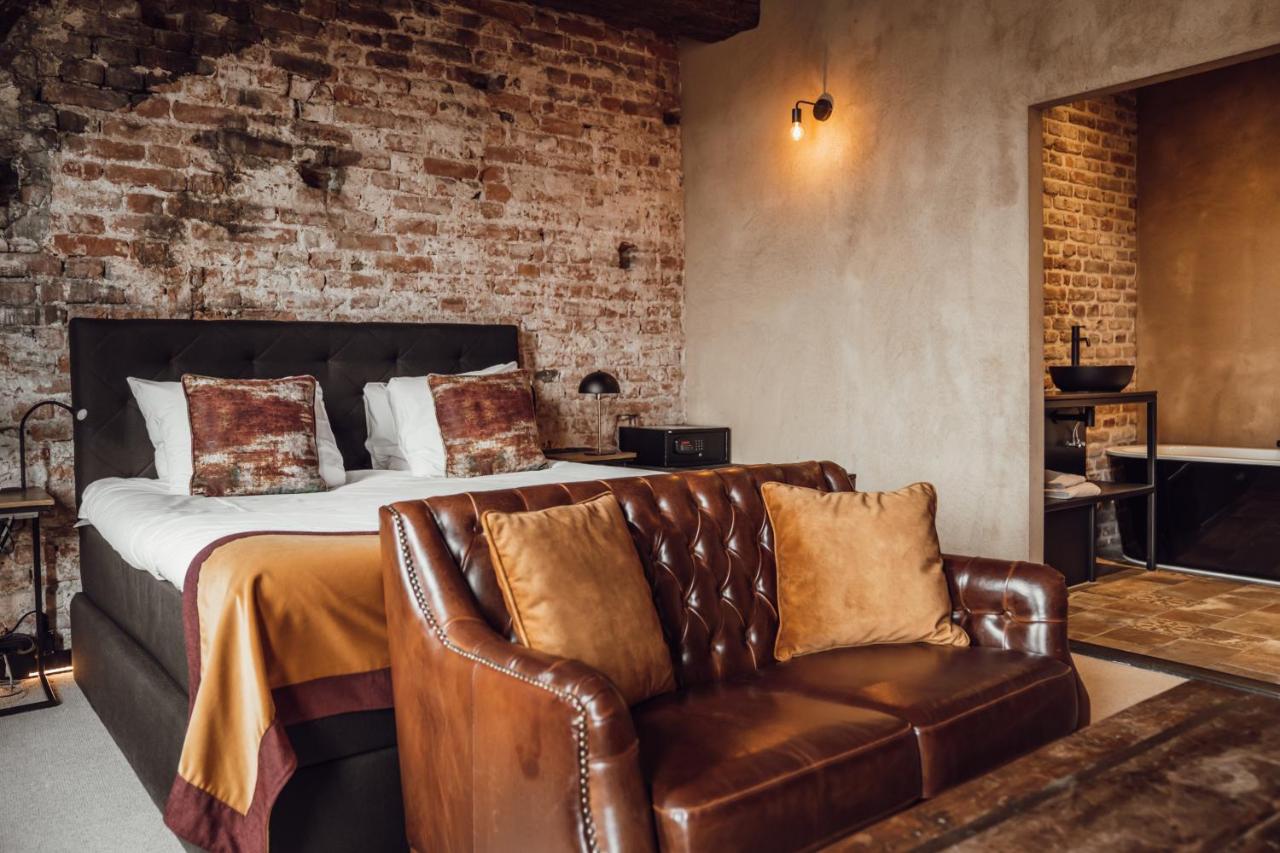 a bedroom with a bed and a leather chair at Broederenklooster in Zutphen