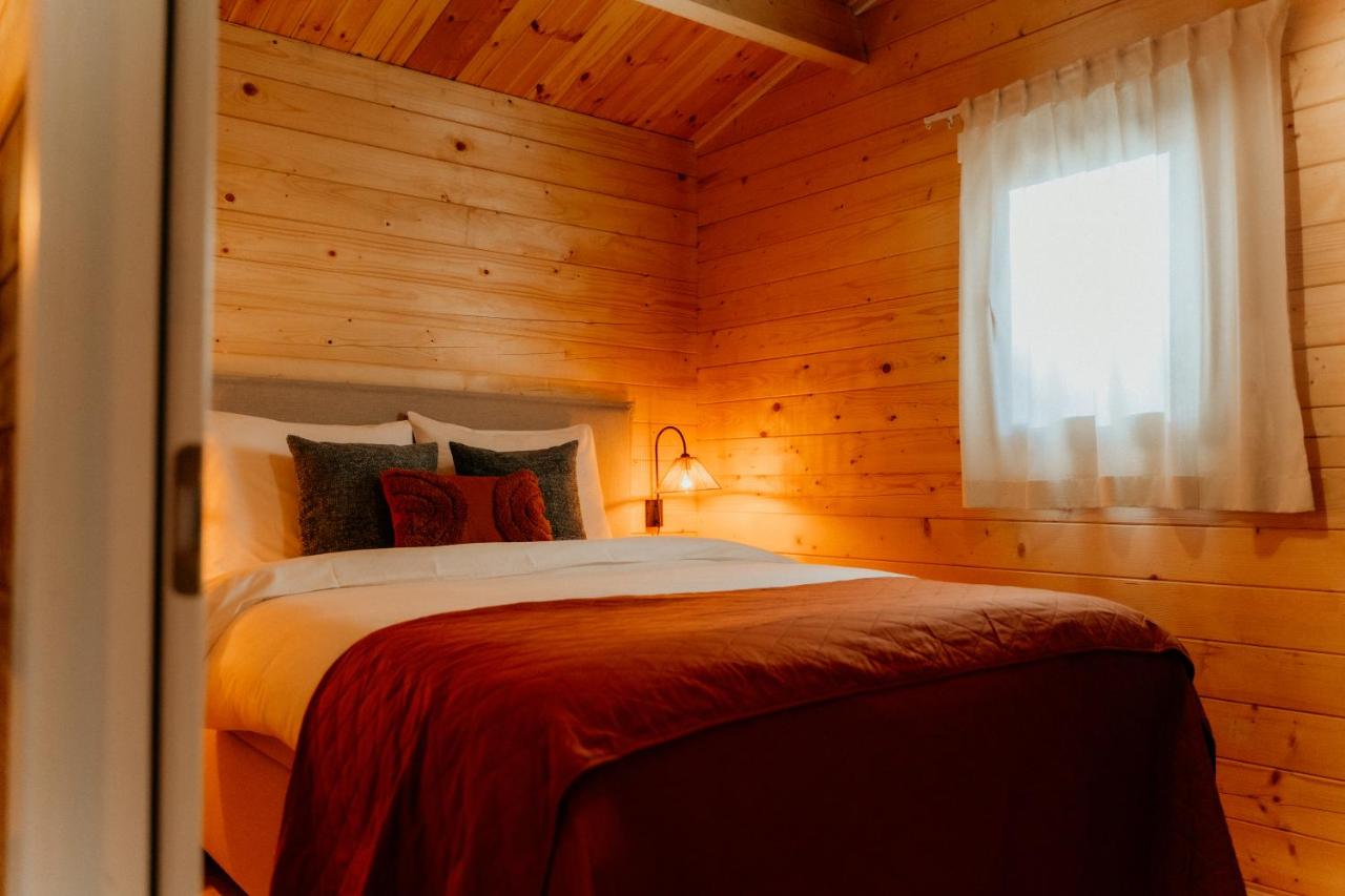 a bedroom with a bed in a wooden room at Romantisch Wellness Boshuisje met Sauna & Hottub in Meijel