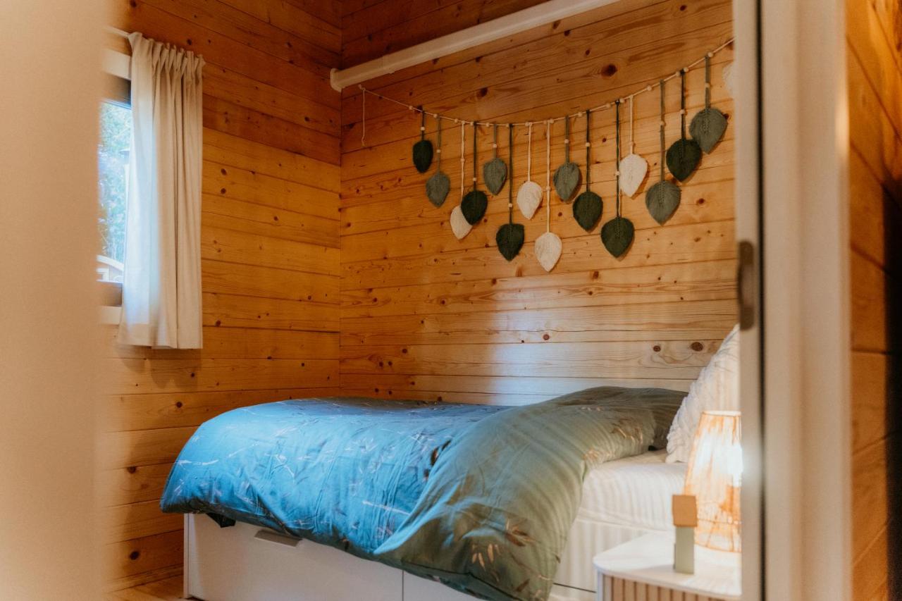 a log cabin bedroom with a bed and a window at Romantisch Wellness Boshuisje met Sauna & Hottub in Meijel