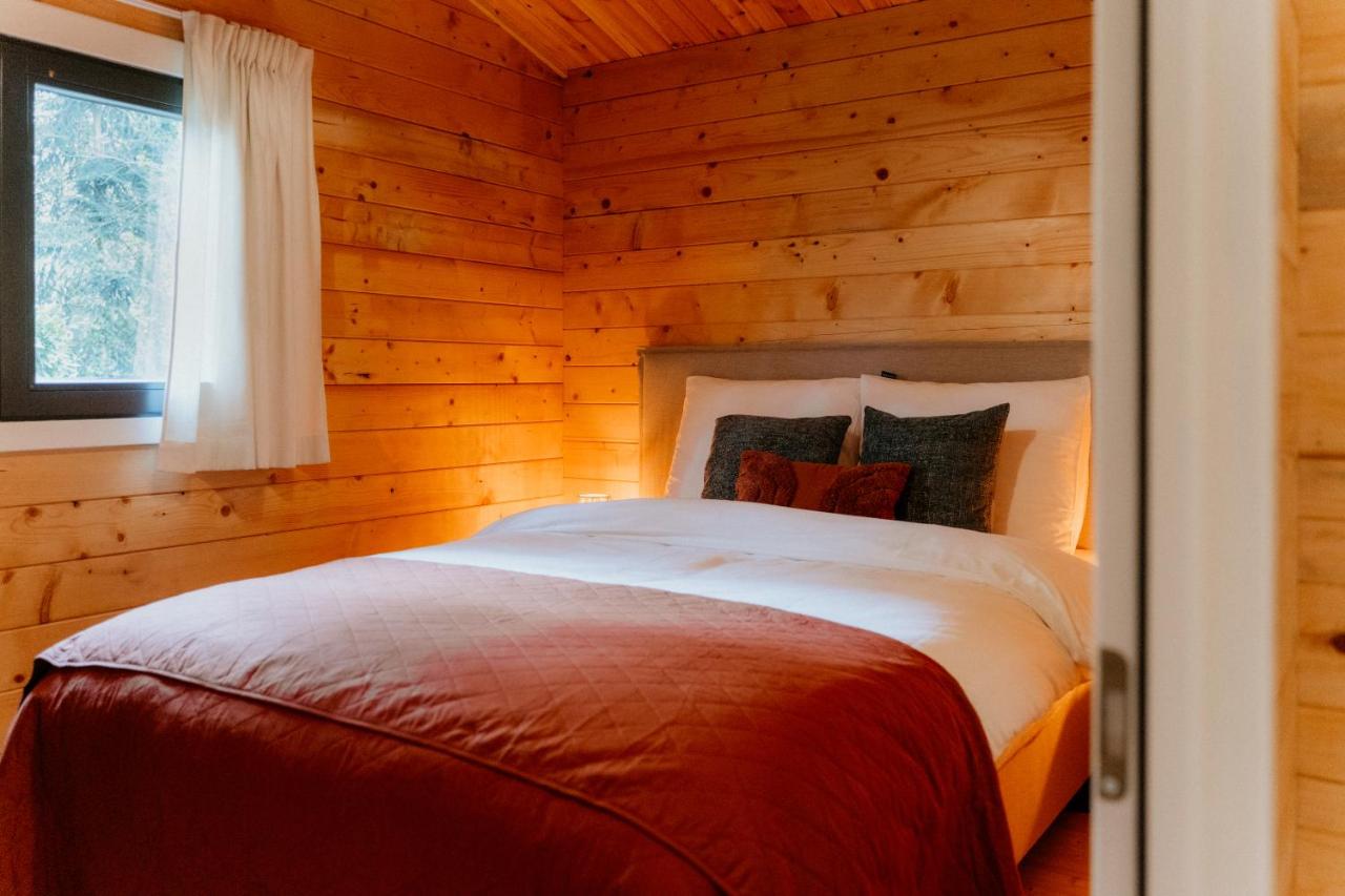 Een bed of bedden in een kamer bij Romantisch Wellness Boshuisje met Sauna & Hottub