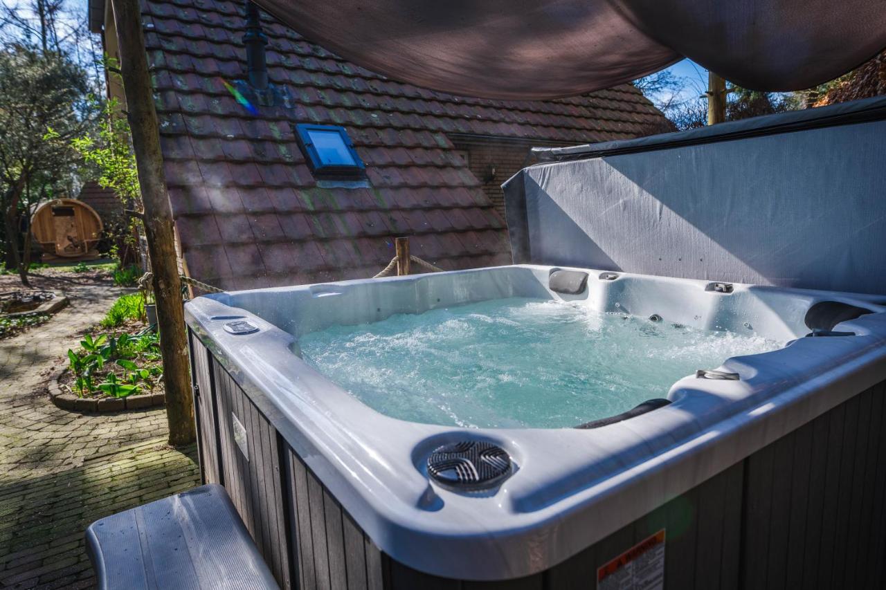 a jacuzzi bathtub in a backyard with at Wellnesshuis met jacuzzi en sauna in het bos in Lunteren