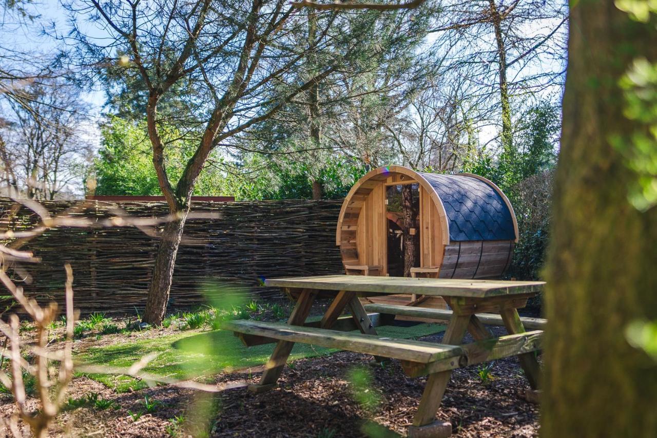 a wooden chair sitting on a picnic table next to a fence at Wellnesshuis met jacuzzi en sauna in het bos in Lunteren