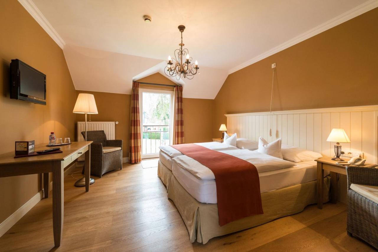 a hotel room with a large bed and a desk at Hotel Eifelland in Butgenbach