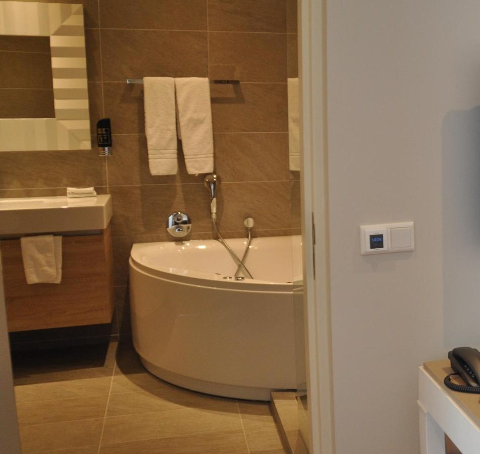 a bathroom with a tub and a sink at Romantik Parkhotel het Gulpdal in Slenaken