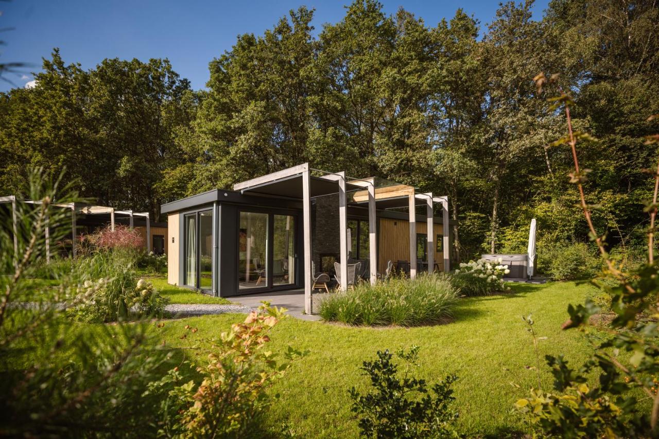a modern house in a garden with trees at Mooi Twente Lodges - privé Spa en sauna in Markelo