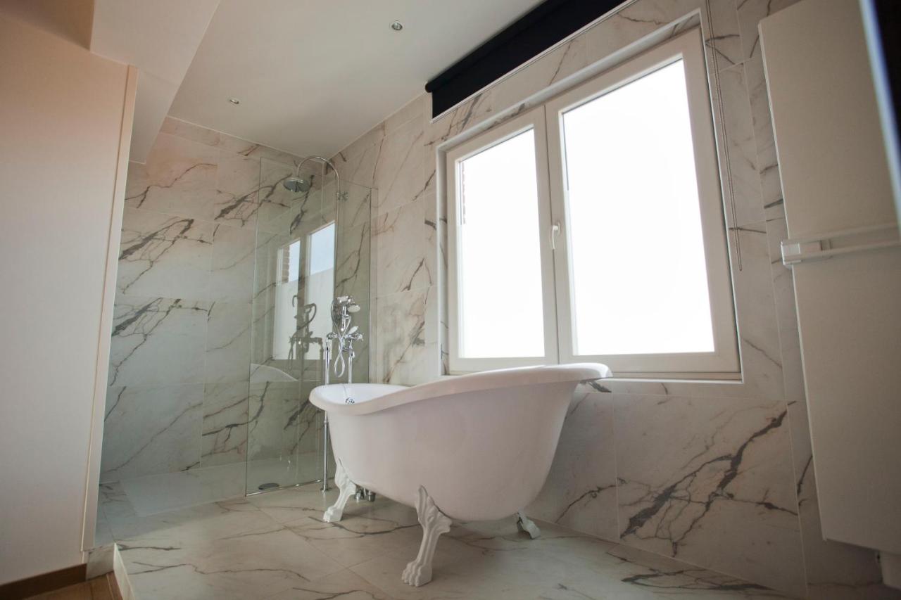 a bath tub in a bathroom with a window at Hotel Carlton in Ghent