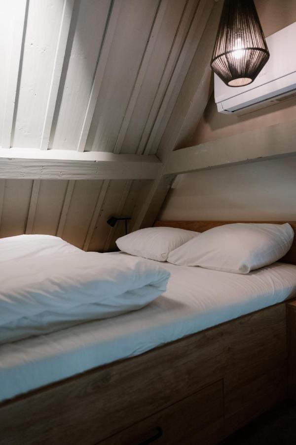 two beds in a small room with a window at Stadsklooster Dordt Hotel&Hostel in Dordrecht