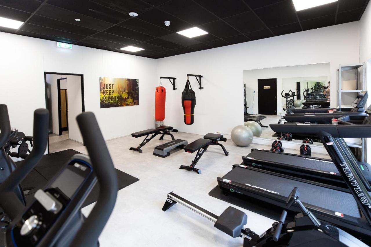 a gym with several treadmills and exercise bikes at Veluwe Hotel De Beyaerd in Hulshorst