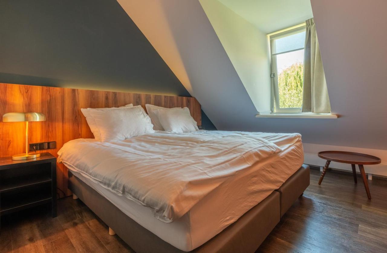 a bedroom with a large bed with a window at Hotel Zutphen in Zutphen