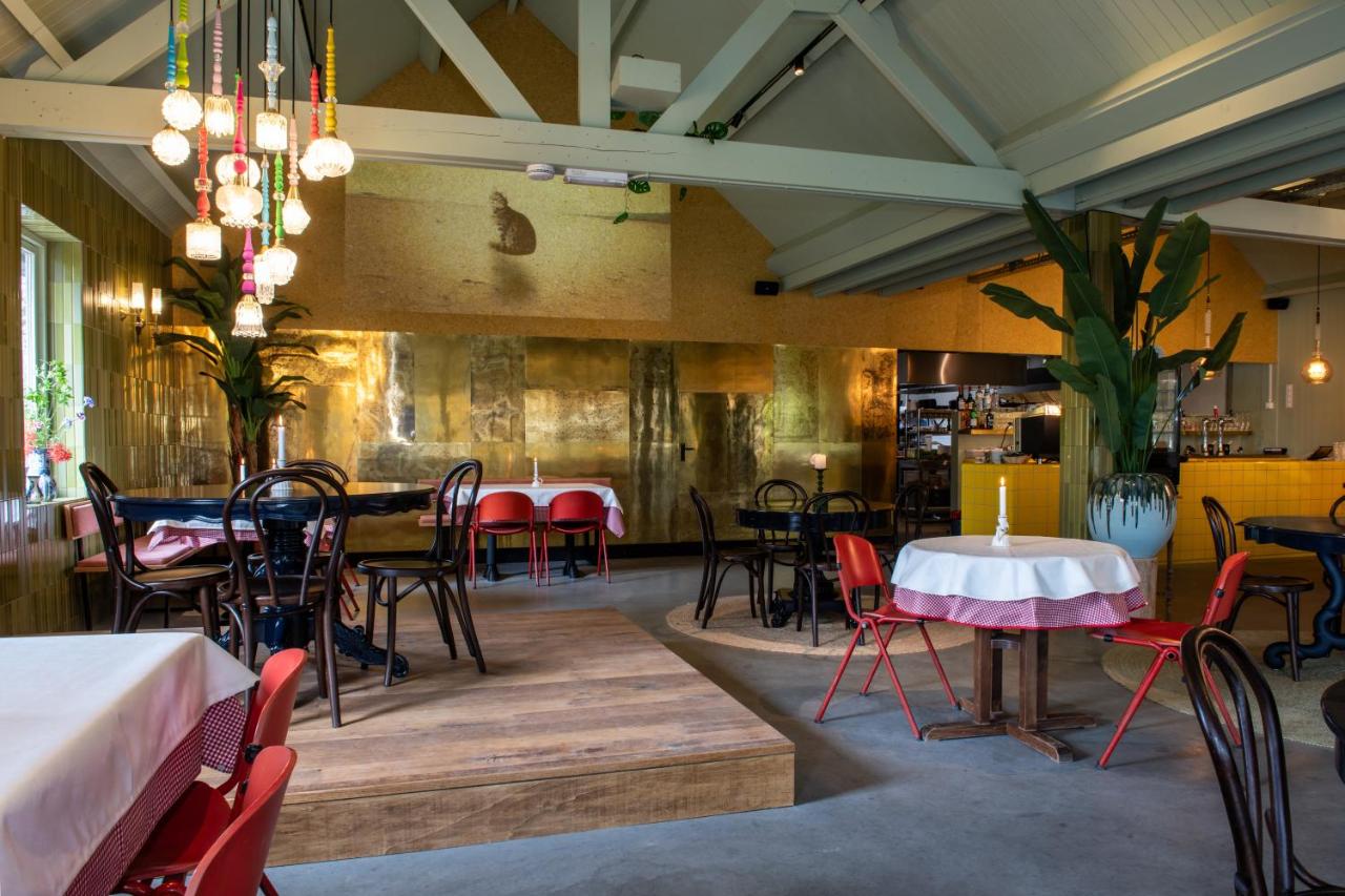 a restaurant with tables and chairs in a room at Fort Vuren in Vuren