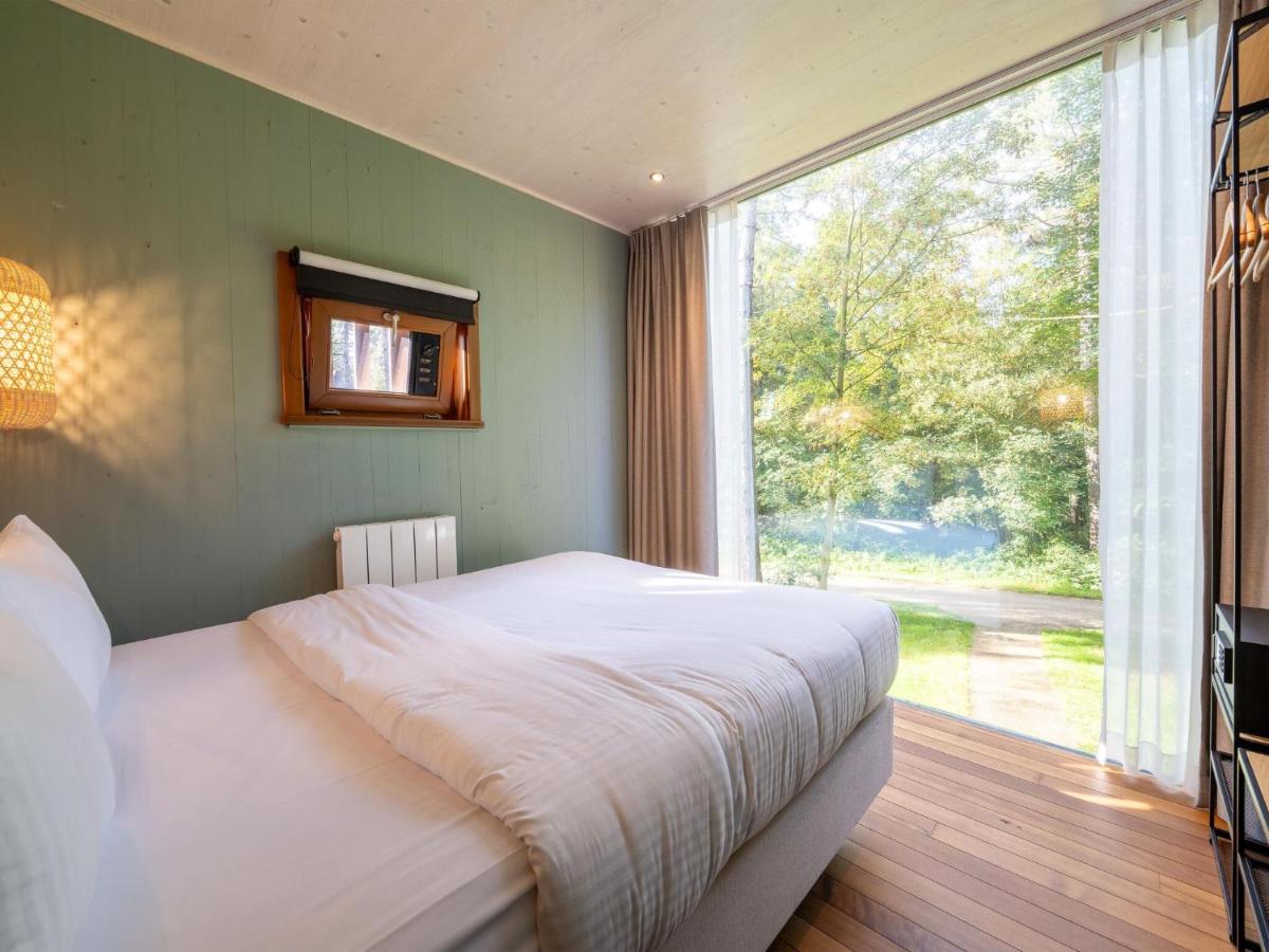 Een bed of bedden in een kamer bij Belvilla Treehouse in woods